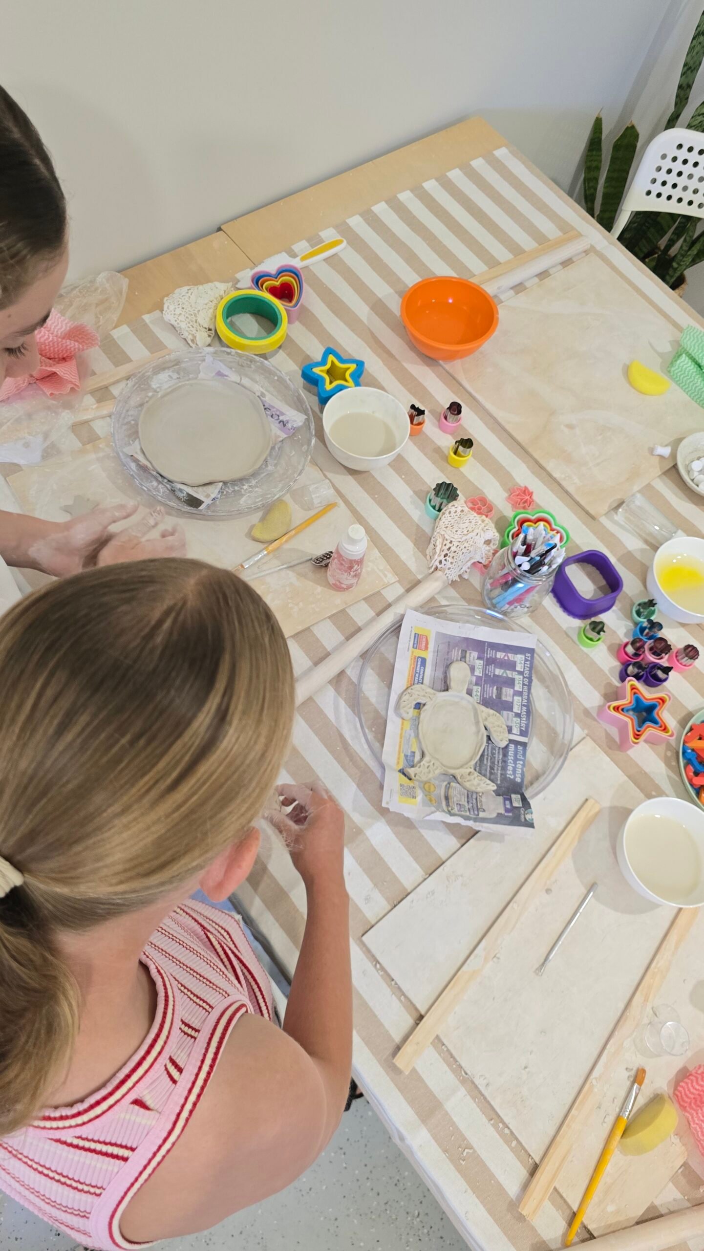 two children doing craft at a table.